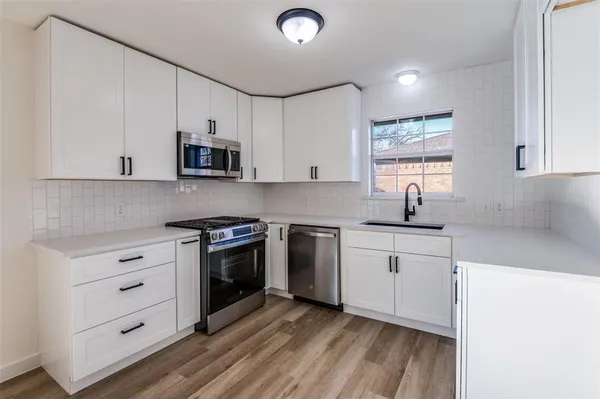 a kitchen with cabinets appliances and a sink