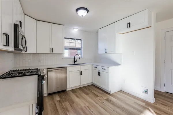 a kitchen with granite countertop white cabinets and white appliances