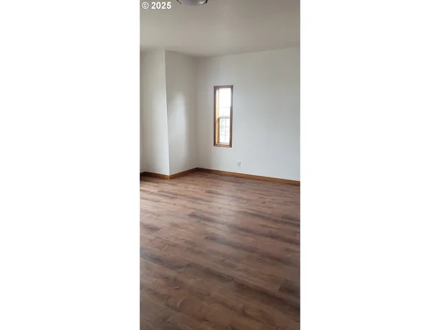 a picture of an empty room with wooden floor