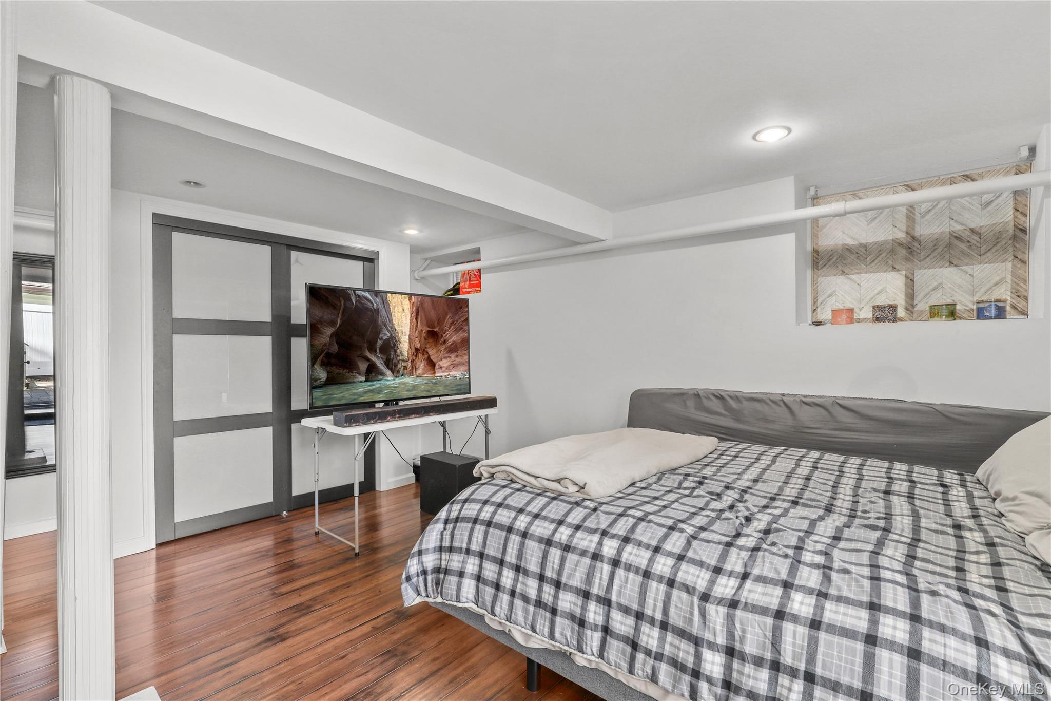 69 Clinton Avenue New Rochelle, NY 10801 - Photo 22 of 29 a bedroom with a bed and wooden floor