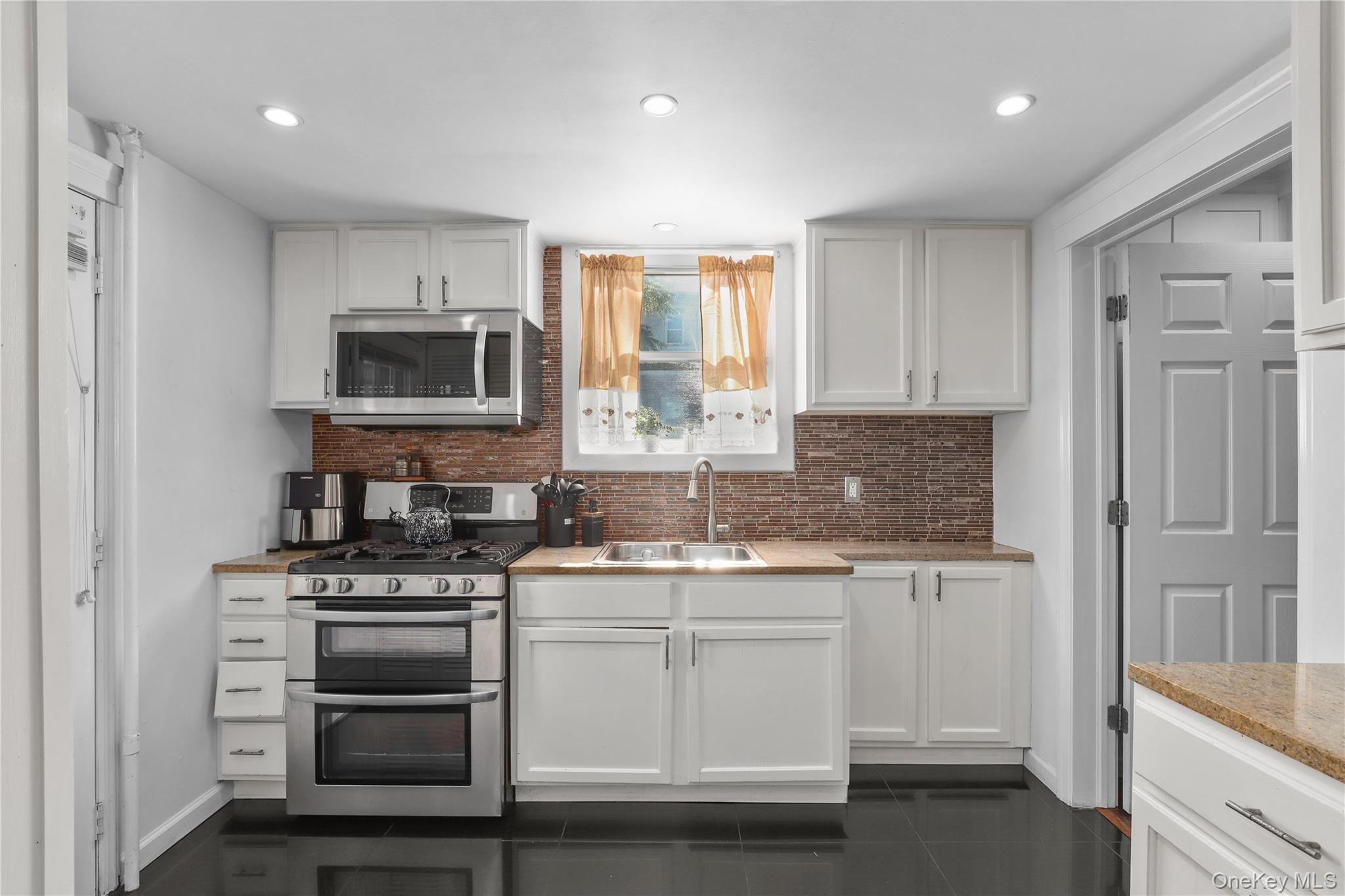 69 Clinton Avenue New Rochelle, NY 10801 - Photo 8 of 29 a kitchen with a sink stove and microwave