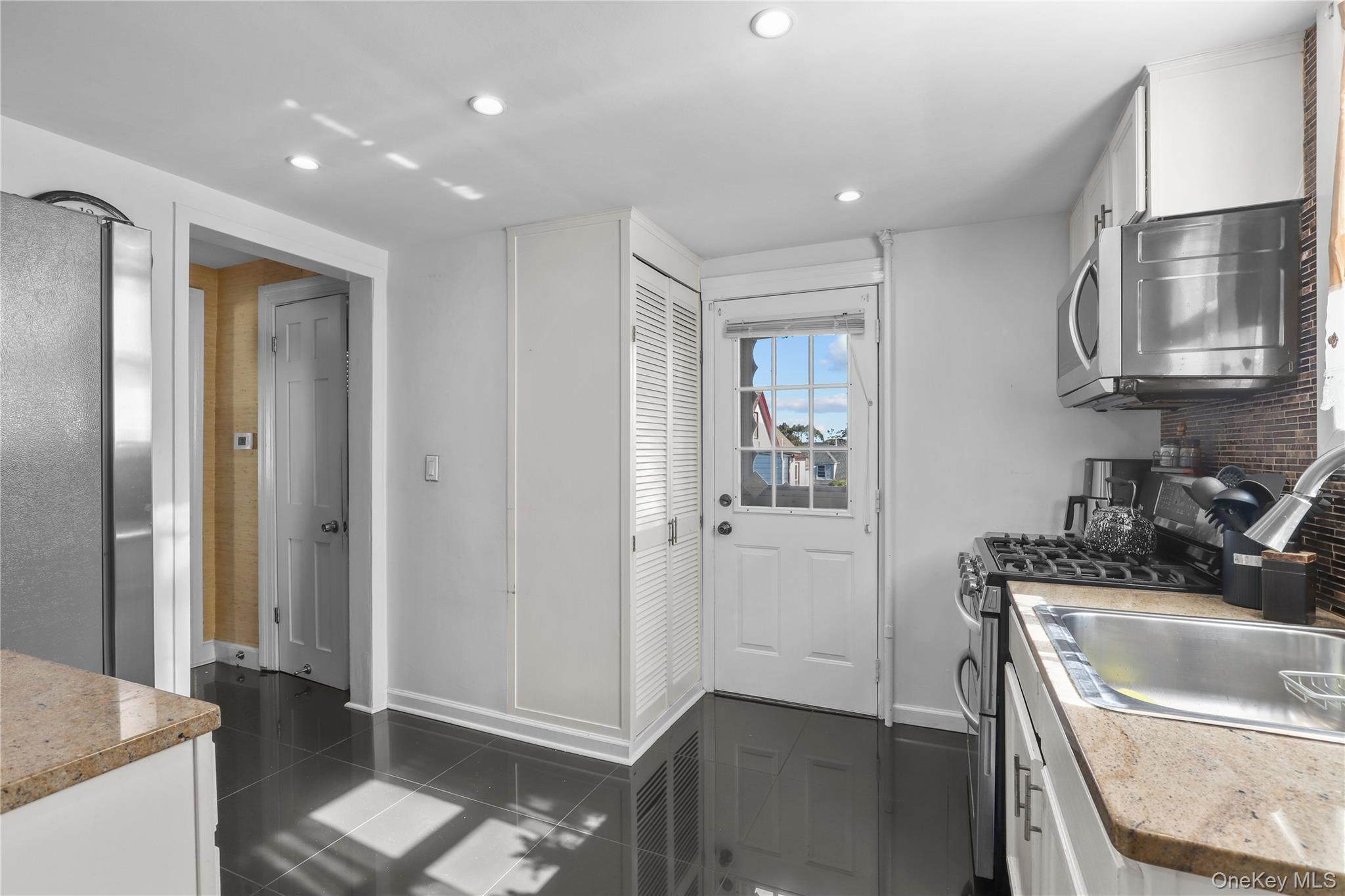 69 Clinton Avenue New Rochelle, NY 10801 - Photo 9 of 29 a kitchen with a sink and a refrigerator