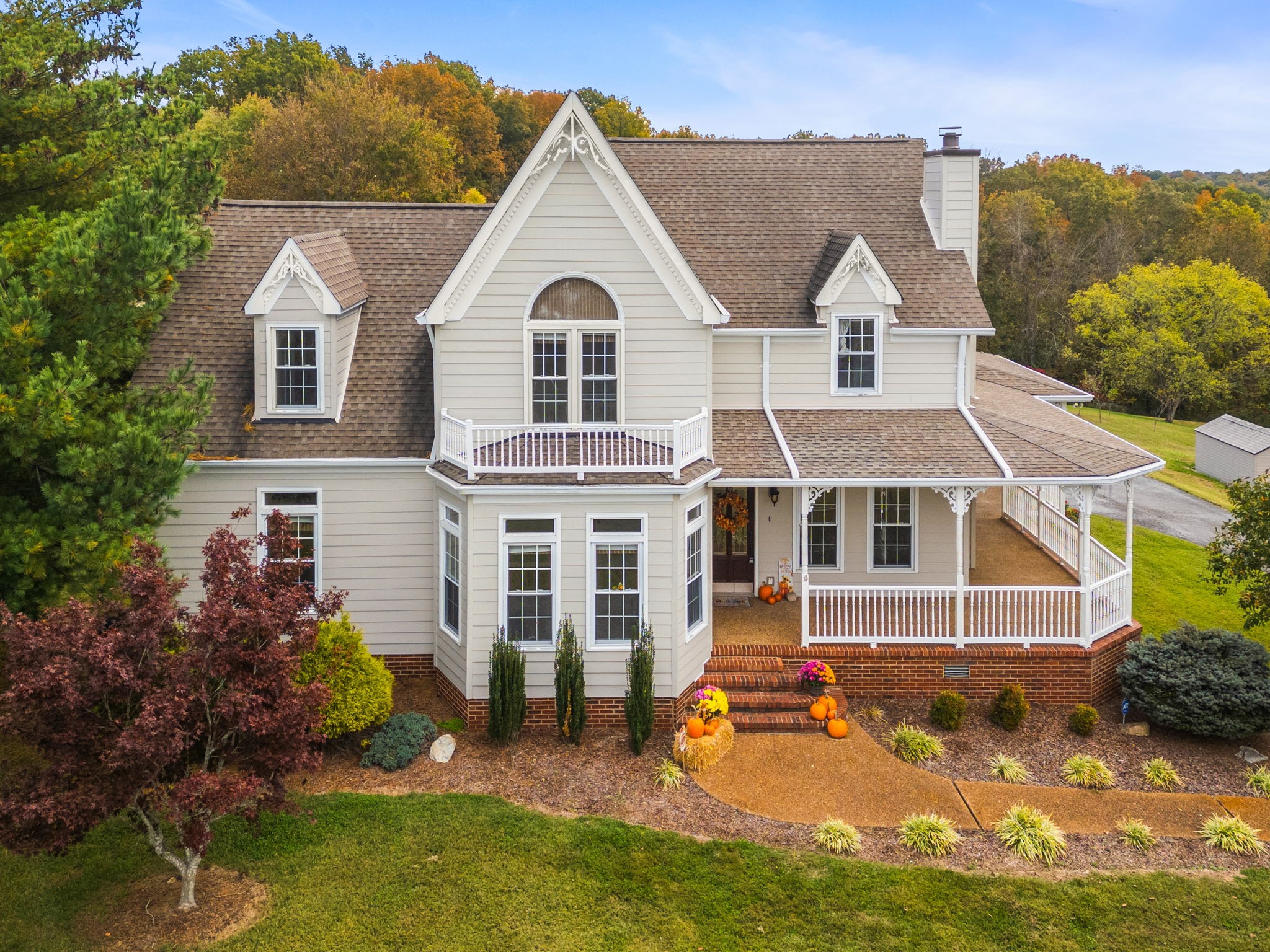 a view of a white house with large windows and a yard