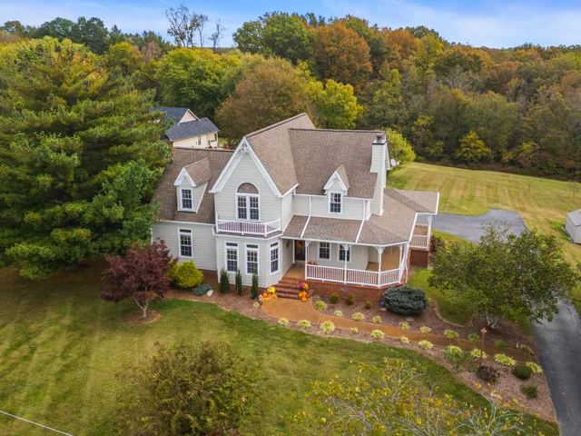 an aerial view of a house with swimming pool and mountains