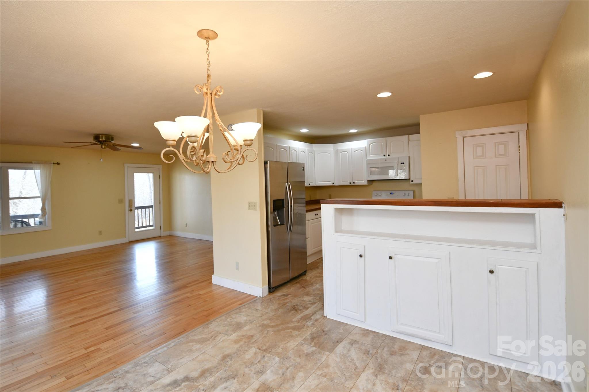 477 West Ridge Drive Burnsville, NC 28714 - Photo 12 of 48 a view of a kitchen with a refrigerator a ceiling fan and wooden floor