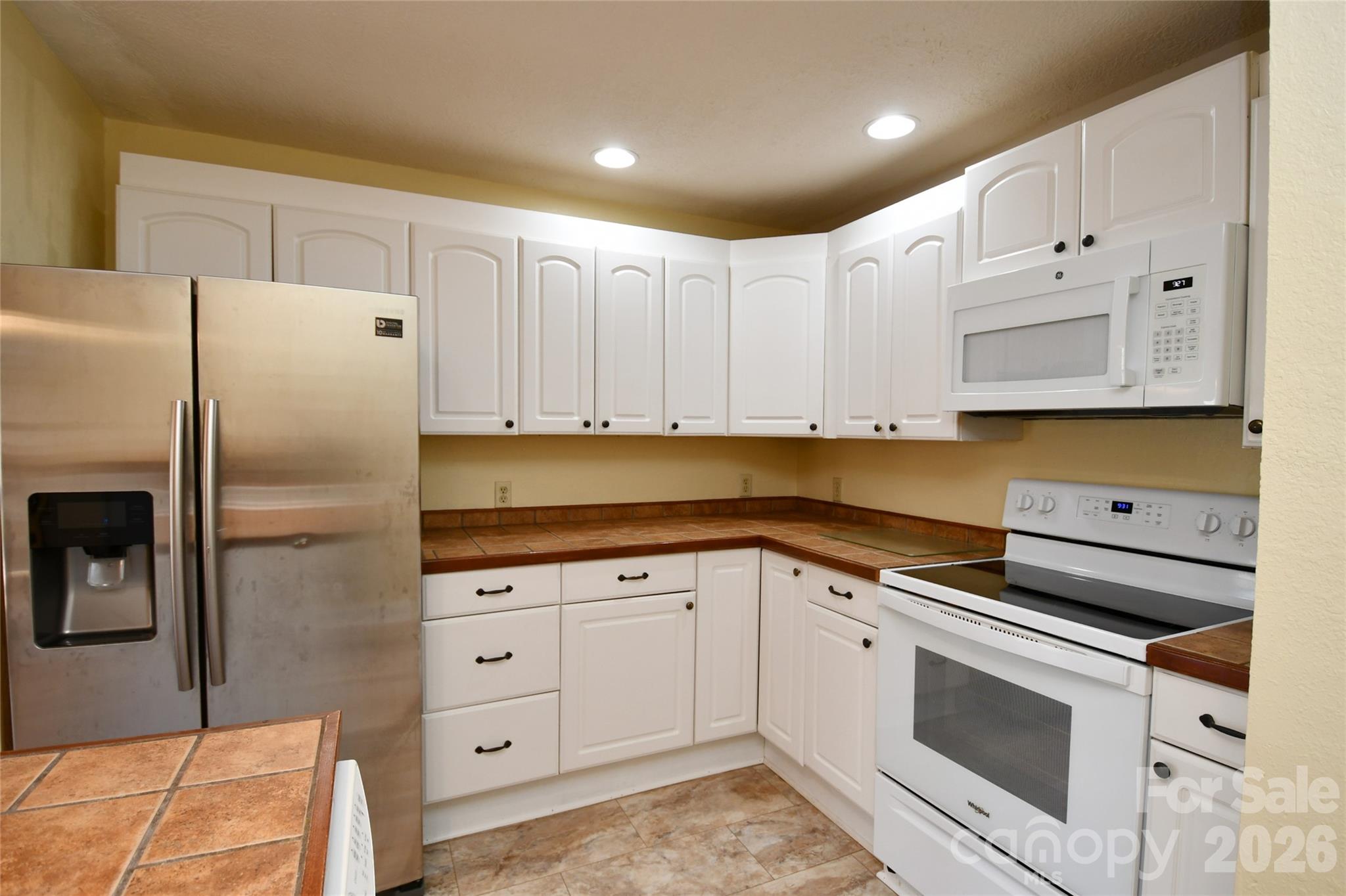 477 West Ridge Drive Burnsville, NC 28714 - Photo 16 of 48 a kitchen with granite countertop white cabinets and refrigerator