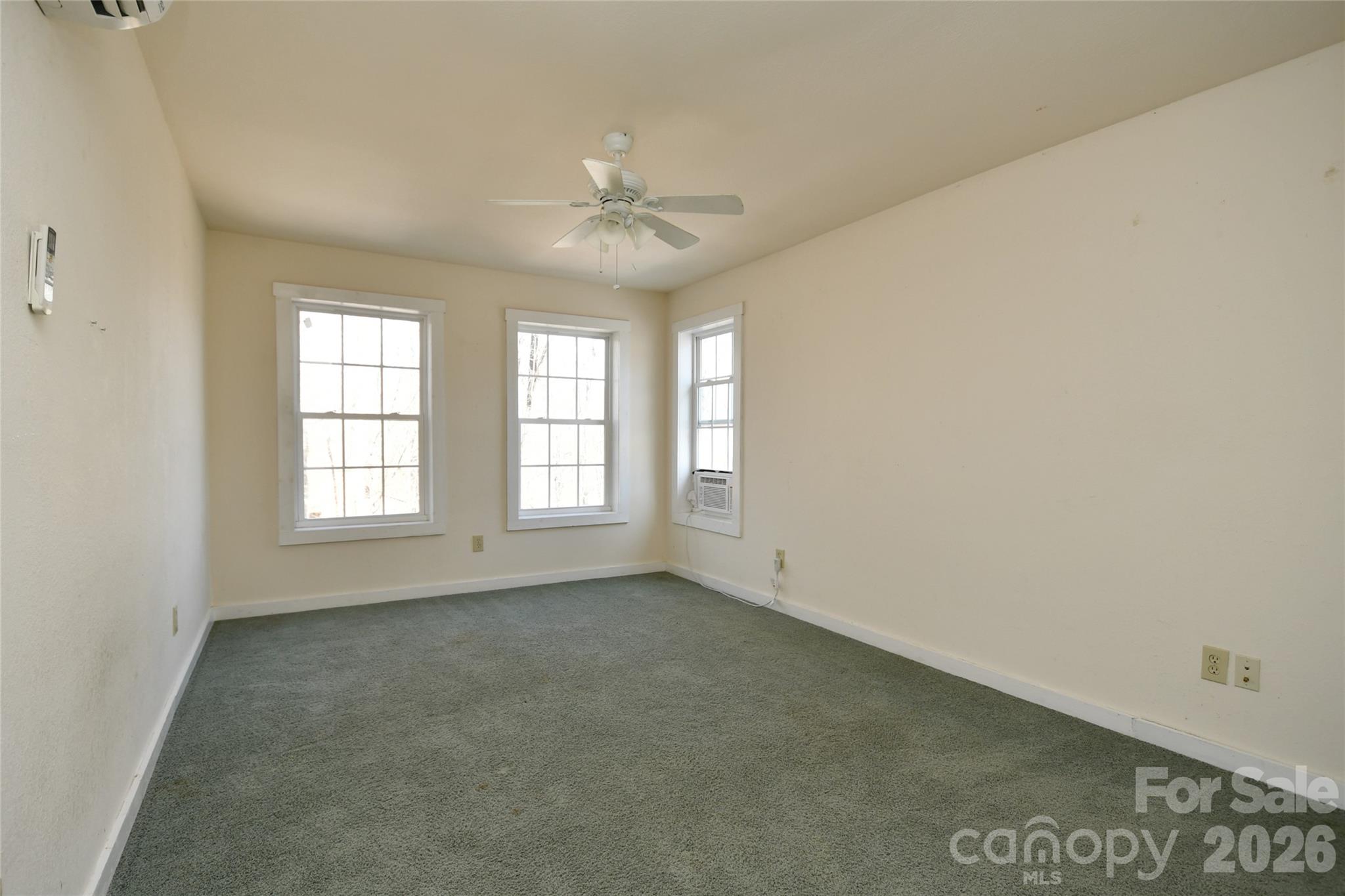 477 West Ridge Drive Burnsville, NC 28714 - Photo 37 of 48 an empty room with chandelier fan and windows