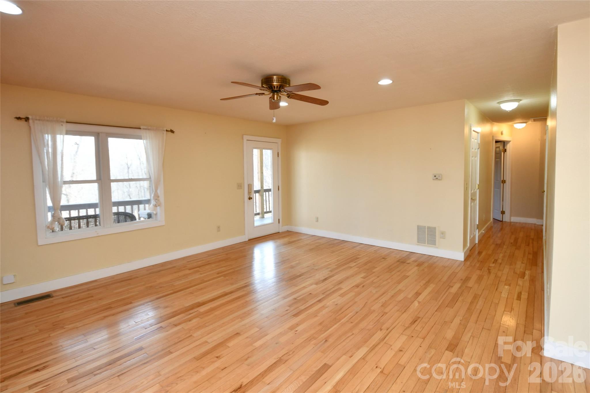 477 West Ridge Drive Burnsville, NC 28714 - Photo 9 of 48 a view of an empty room with wooden floor and a window