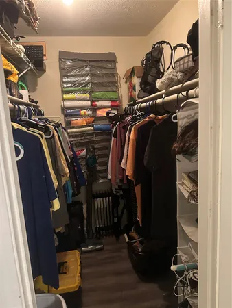 a view of walk in closet with clothes and shoes