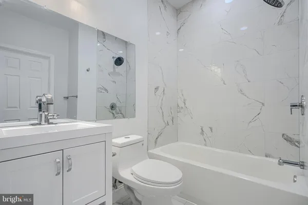 a bathroom with a sink toilet vanity and shower