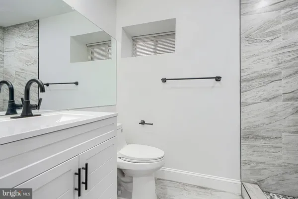 a bathroom with a toilet a sink and mirror