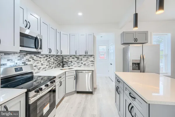 a kitchen with stainless steel appliances a sink stove and refrigerator