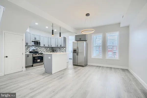 a kitchen with stainless steel appliances a refrigerator sink and cabinets