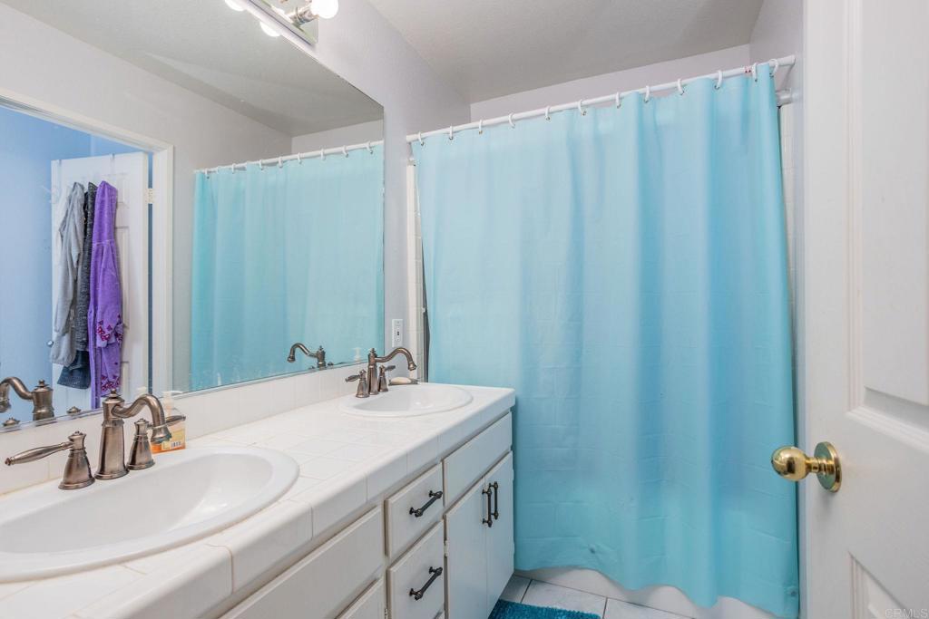 4895 Lake Shore Place Fallbrook, CA 92028 - Photo 8 of 27 a bathroom with a double vanity sink and a mirror