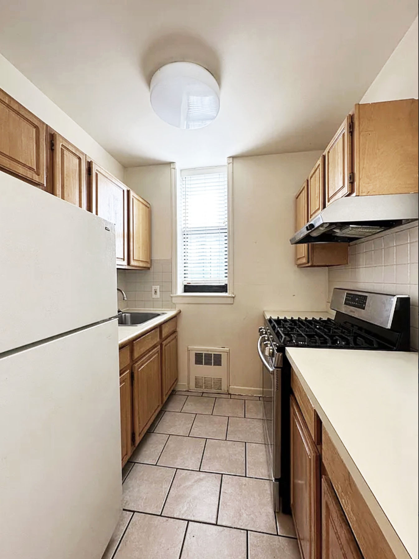 Undisclosed Address Manhattan, NY 10032 - Photo 4 of 8 a kitchen with a cabinets and white appliances