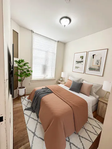 a bedroom with a bed and a potted plant