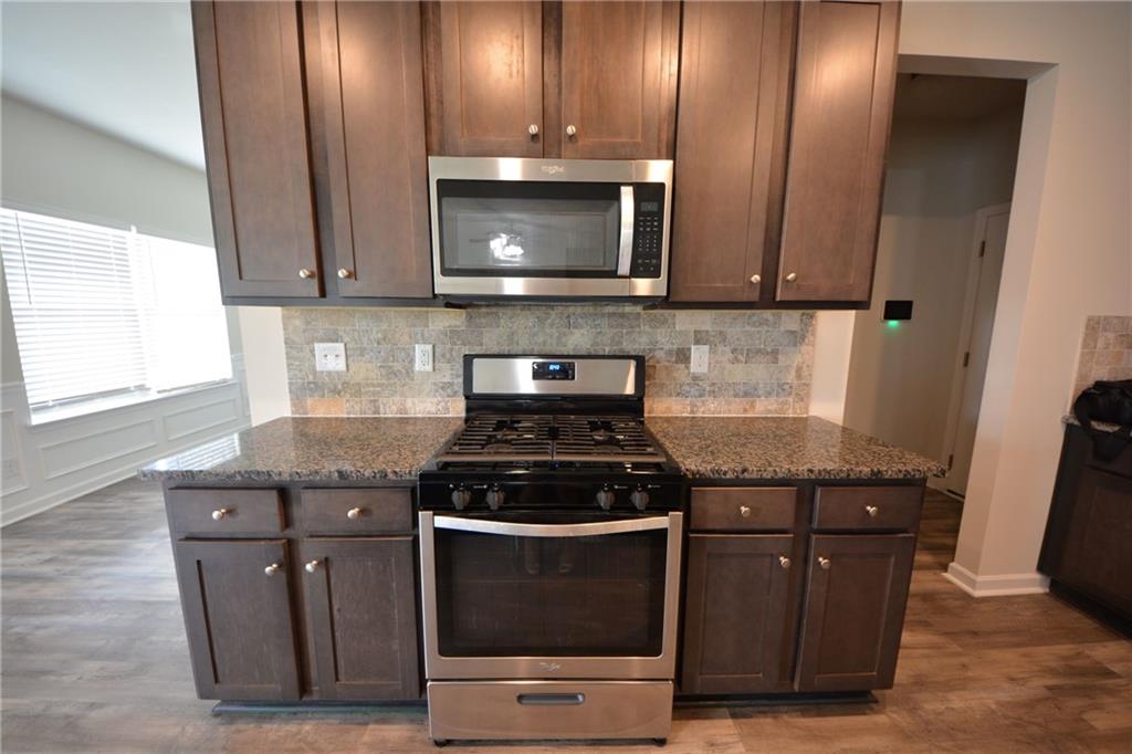 2377 Ticonic Road Lithonia, GA 30058 - Photo 19 of 40 a kitchen with stainless steel appliances granite countertop a stove and a microwave