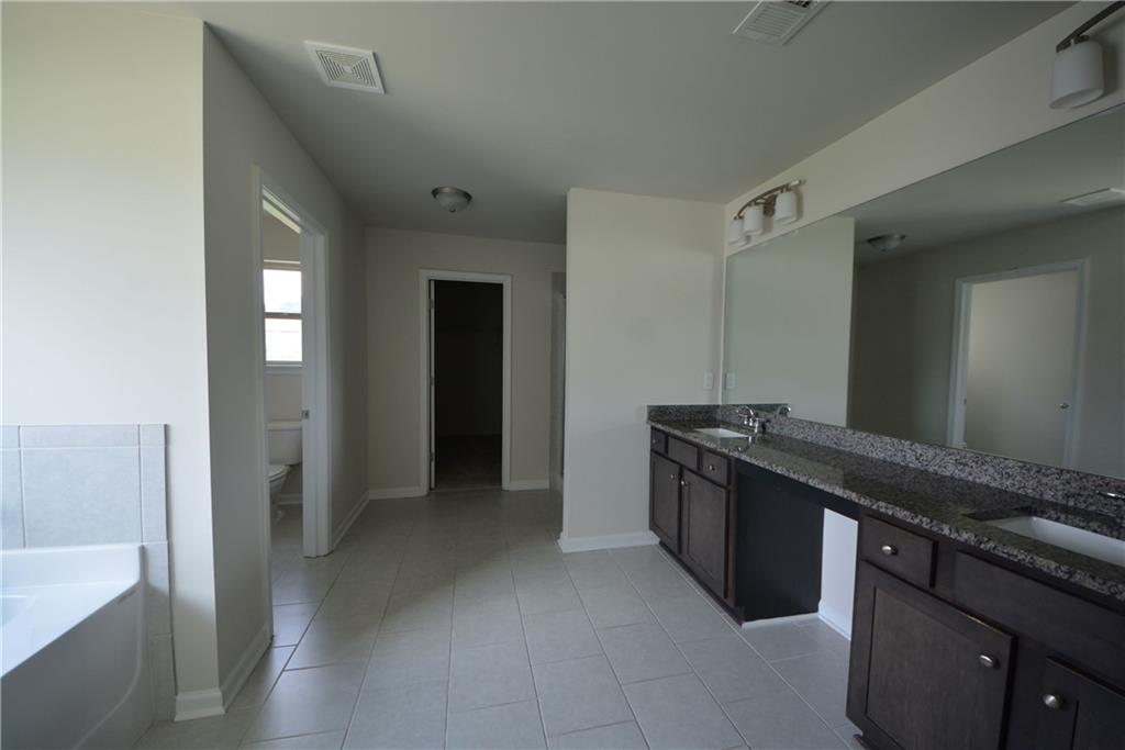 2377 Ticonic Road Lithonia, GA 30058 - Photo 31 of 40 a kitchen with granite countertop a stove and a refrigerator