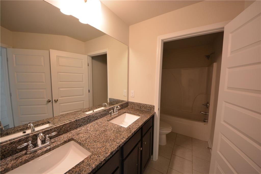 2377 Ticonic Road Lithonia, GA 30058 - Photo 38 of 40 a bathroom with a granite countertop sink and a mirror