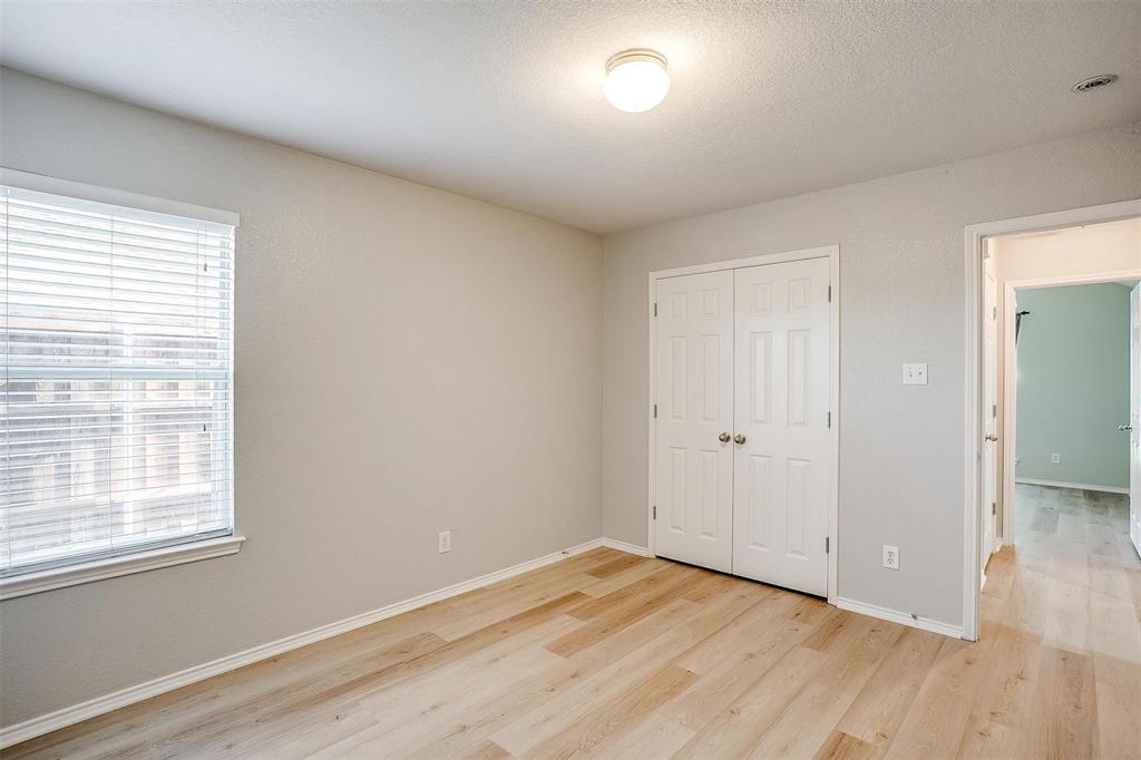 543 Thistle Meade Circle Burleson, TX 76028 - Photo 12 of 23 a view of an empty room with wooden floor and a window