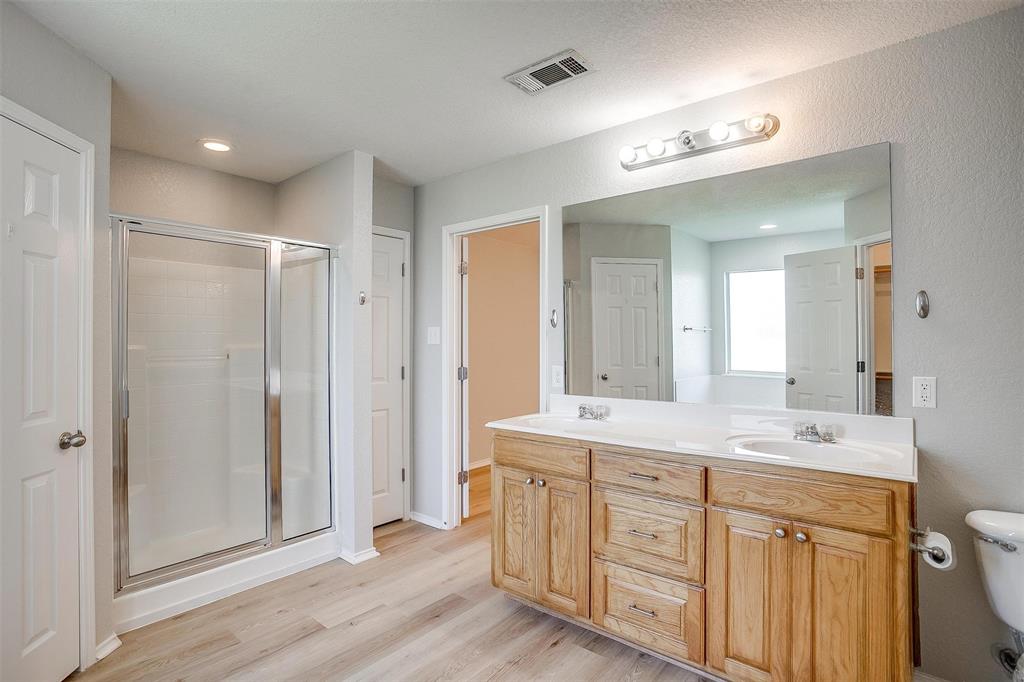 543 Thistle Meade Circle Burleson, TX 76028 - Photo 20 of 23 a spacious bathroom with a double vanity sink a large mirror a shower and vanity