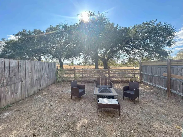 a backyard of a house with table and chairs