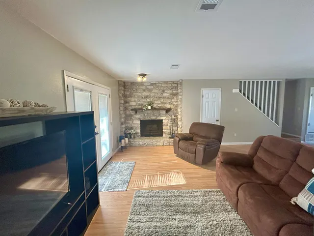a living room with furniture a flat screen tv and kitchen view