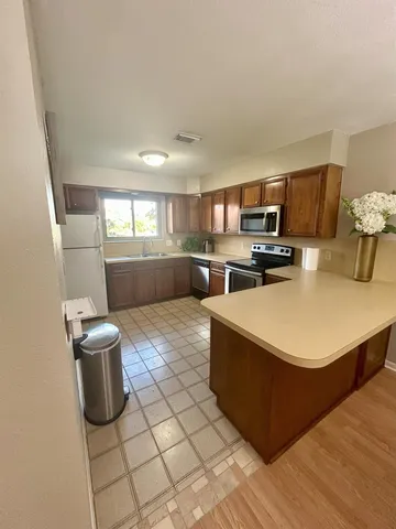a kitchen with a sink a stove top oven and wooden floor