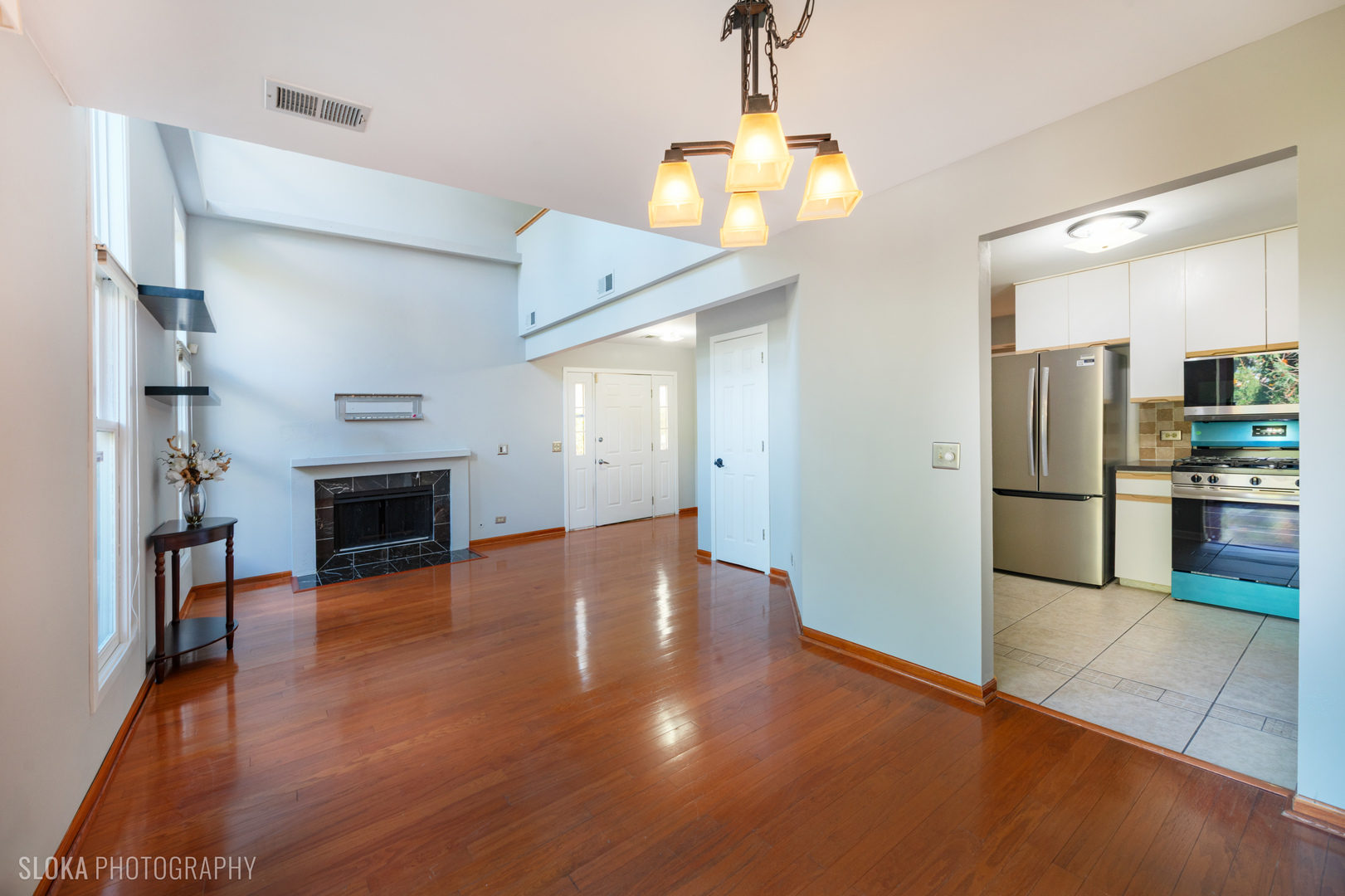 2342 Hamilton Place Schaumburg, IL 60107 - Photo 9 of 25 a view of a livingroom with a fireplace wooden floor and a kitchen