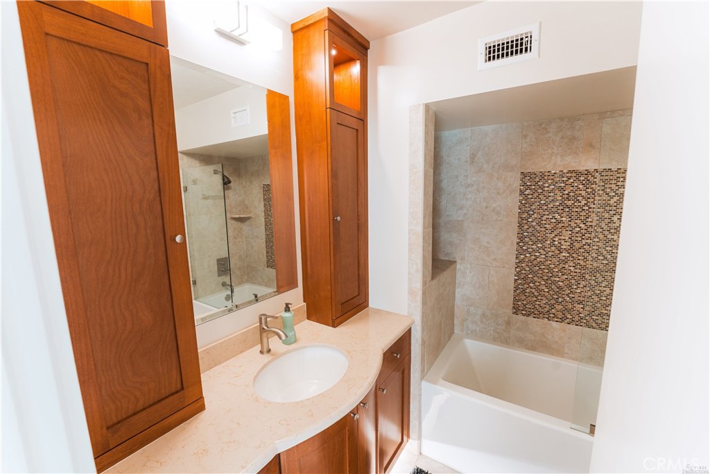 16 South 36th Place, Unit F Long Beach, CA 90803 - Photo 10 of 28 a bathroom with a granite countertop sink and a mirror