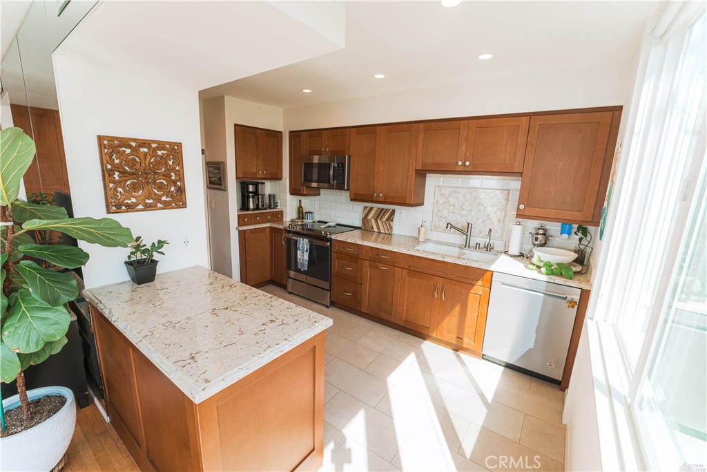16 South 36th Place, Unit F Long Beach, CA 90803 - Photo 14 of 28 a kitchen with a sink refrigerator and microwave