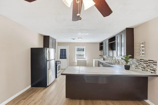 a kitchen with stainless steel appliances kitchen island granite countertop a stove and a sink