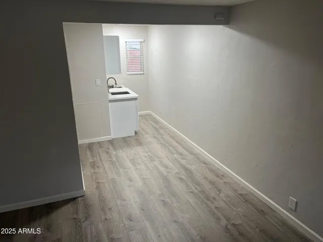 a view of a hallway with wooden floor and cabinets