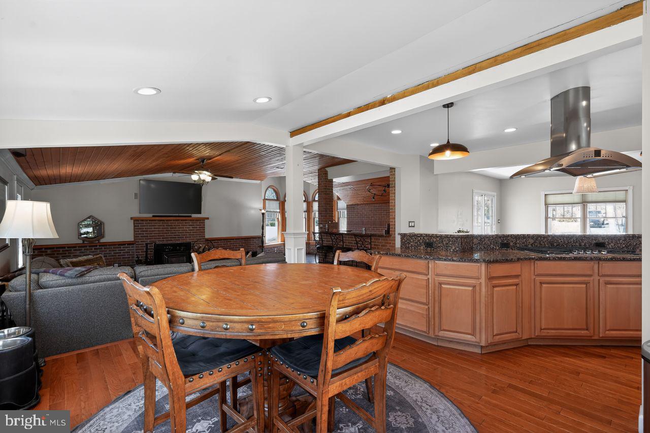 21 Mill Road Shamong, NJ 08088 - Photo 18 of 52 a dining hall with stainless steel appliances kitchen island granite countertop a table chairs and a refrigerator
