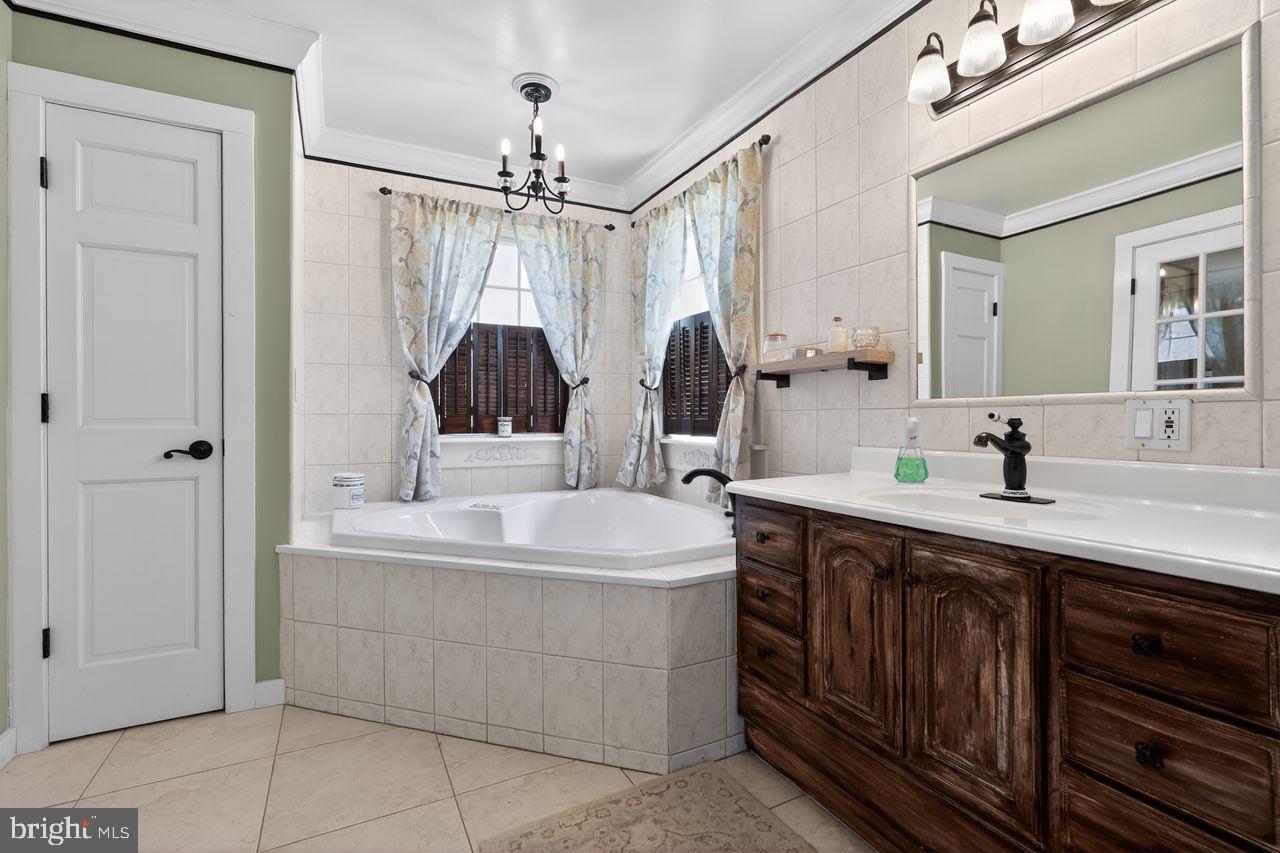 21 Mill Road Shamong, NJ 08088 - Photo 31 of 52 a bathroom with a double vanity sink a mirror a bathtub and shower