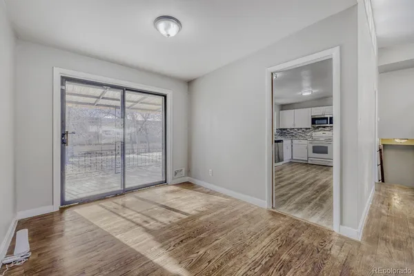 a view of a room with wooden floor and a bedroom