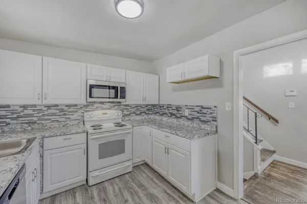 a kitchen with white cabinets stainless steel appliances and sink