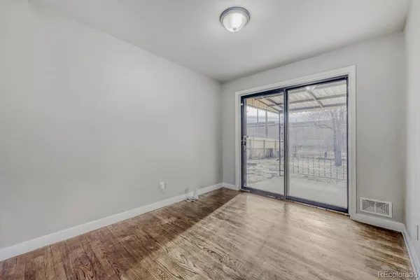 an empty room with wooden floor and sliding door