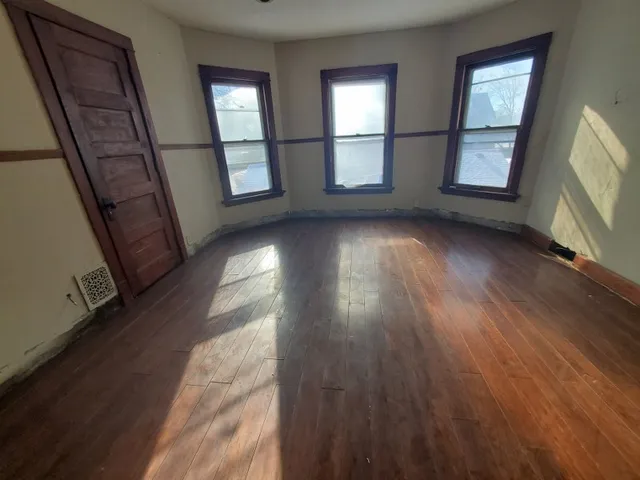 wooden floor in an empty room with a window