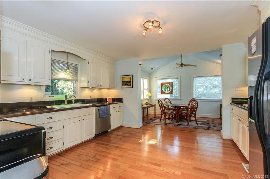 2908 Clover Road Charlotte, NC 28211 - Photo 12 of 27 a kitchen with stainless steel appliances granite countertop a stove top oven a sink dishwasher a dining table and chairs with wooden floor