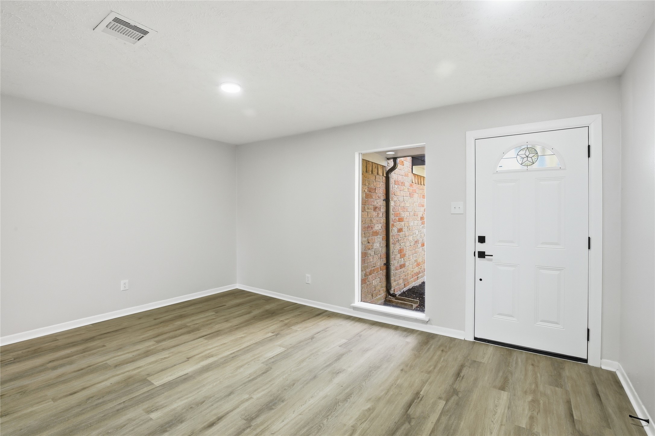9850 Sageroyal Lane Houston, TX 77089 - Photo 2 of 18 an empty room with wooden floor and windows