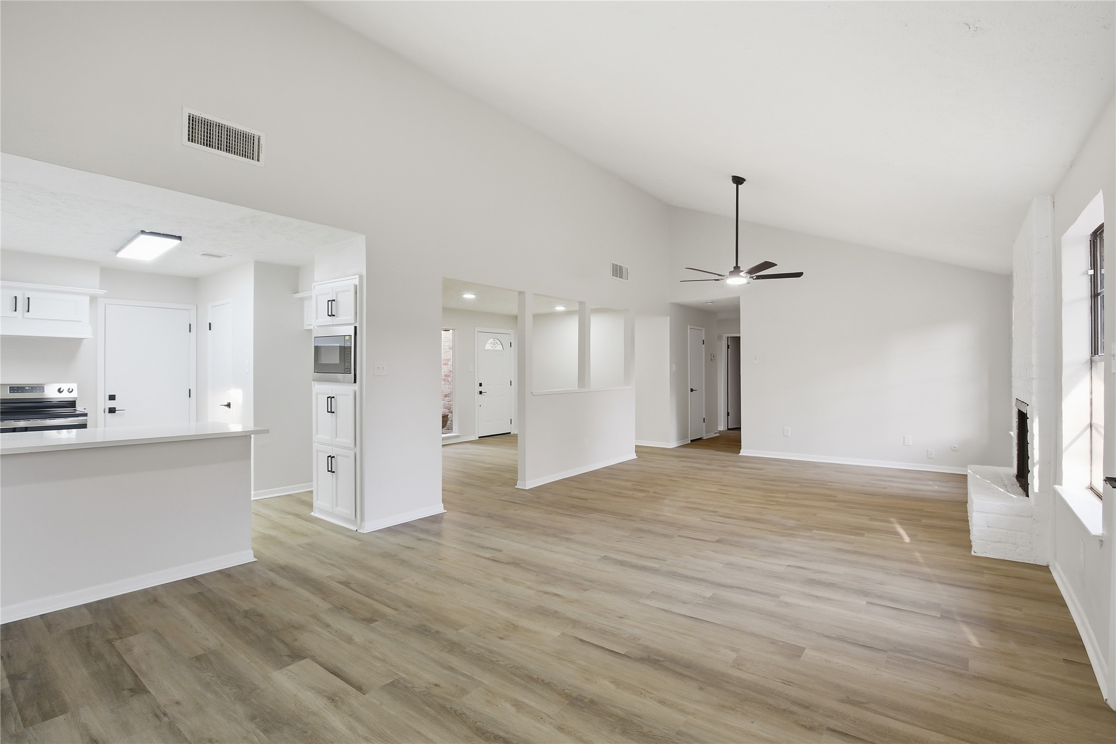 9850 Sageroyal Lane Houston, TX 77089 - Photo 9 of 18 a view of empty room with wooden floor and kitchen