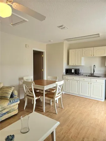 a view of kitchen with granite countertop white cabinets and stainless steel appliances