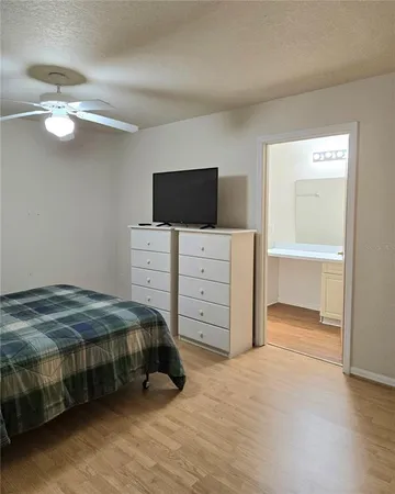 a bedroom with a bed and a flat tv screen on dresser