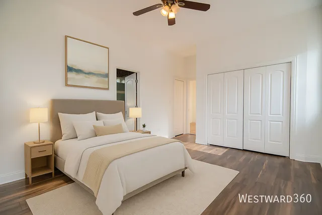 a spacious bedroom with a bed and a painting on the wall