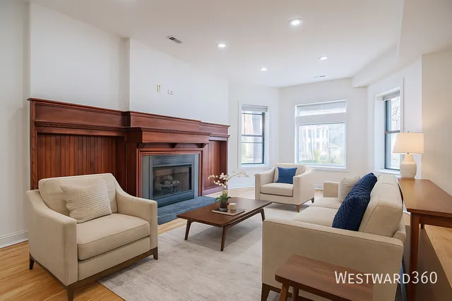 a living room with furniture a fireplace and a large window