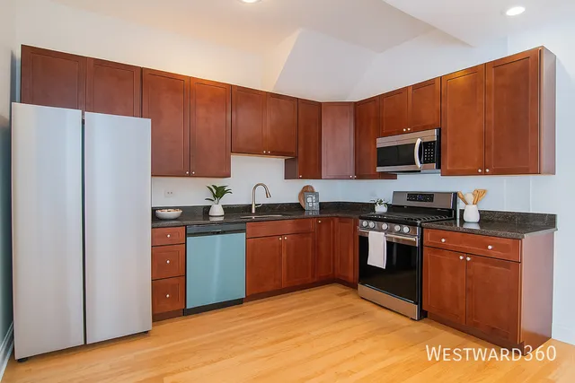 a kitchen with stainless steel appliances granite countertop a stove a sink dishwasher and a refrigerator