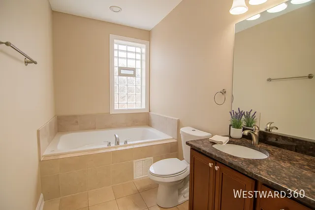 a bathroom with a granite countertop sink a toilet and bathtub
