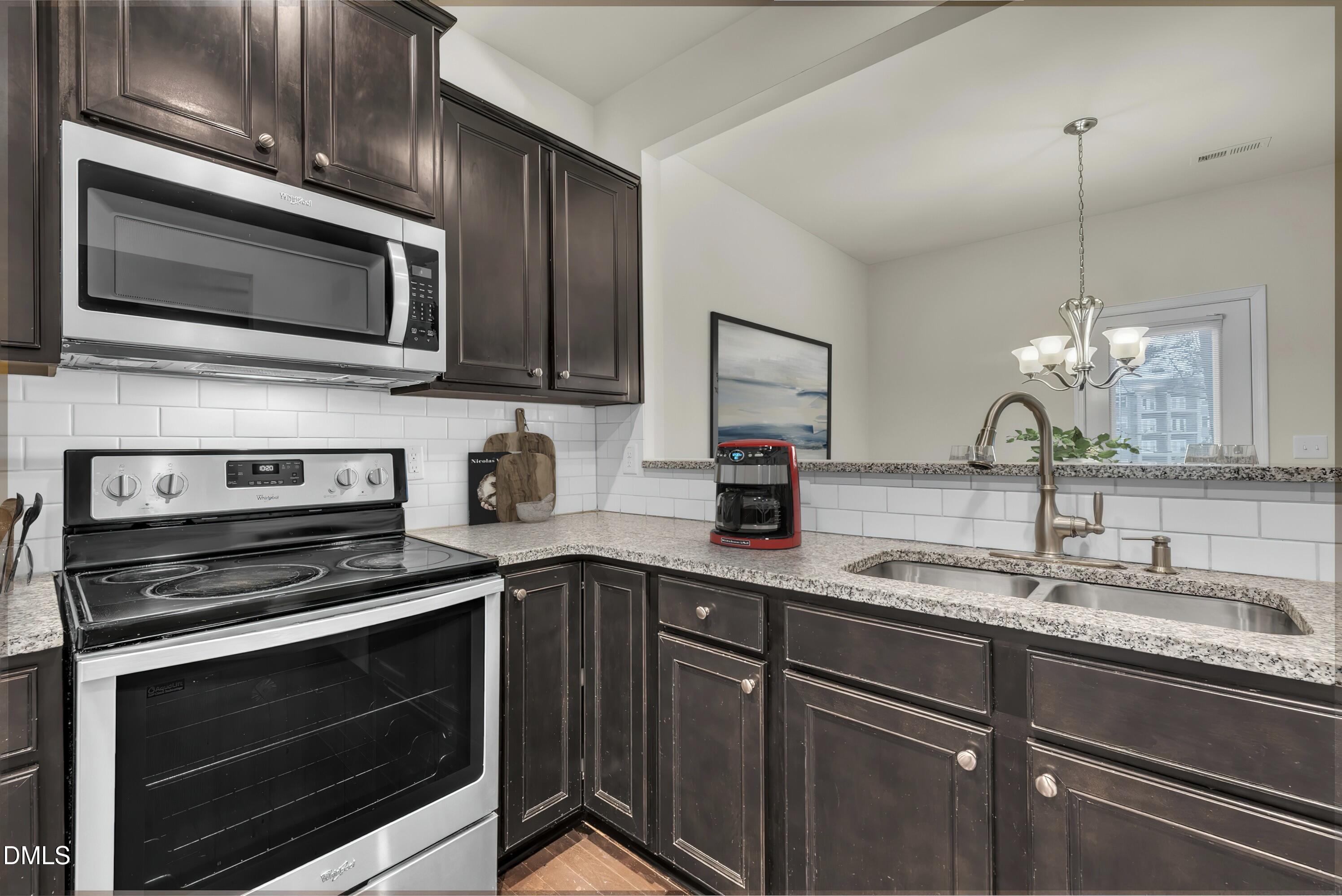 519 Brier Crossings Loop Durham, NC 27703 - Photo 13 of 36 a kitchen with stainless steel appliances a stove microwave and sink