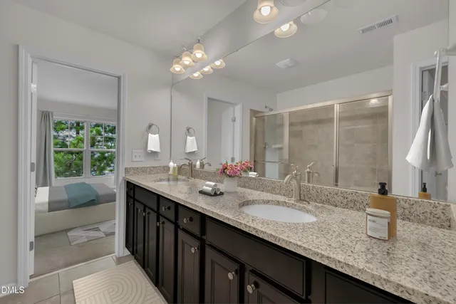 a bathroom with double vanity sinks a vanity a lamp and a mirror